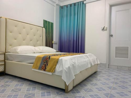 una camera da letto con un grande letto con una grande testiera di Ontrack Travel a Città di Malé