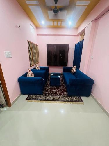 a living room with two blue couches in a room at apartment by Xoyo in Varanasi