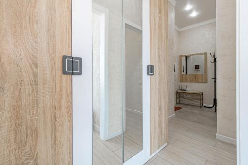 a hallway with a sliding glass door with a mirror at Expo new life 2 in Prigorodnyy