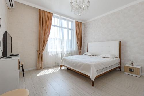 a white bedroom with a bed and a window at Expo new life 2 in Prigorodnyy