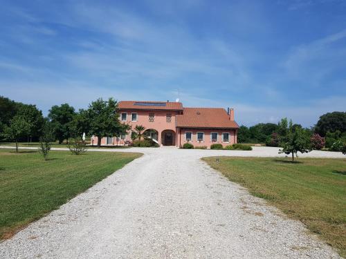 a road leading to a large pink house at Agriturismo Casa Rossa in Postioma