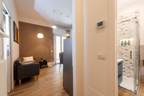 a hallway with a living room with a chair and a refrigerator at APARTMENT BONCIARI PERUGIA Comodo e moderno bilocale con posto auto gratuito e self check in in Perugia