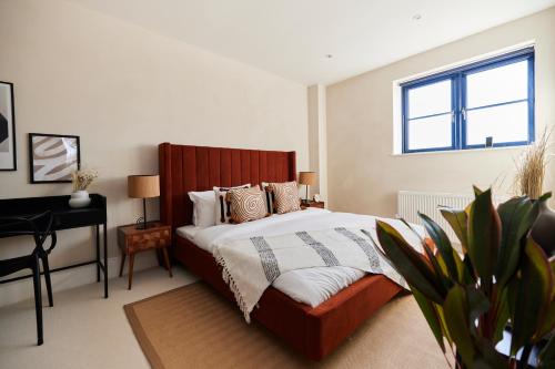 um quarto com uma cama, uma secretária e uma janela em The Tooting Escape - Glamorous 3BDR Flat with Balcony em Londres