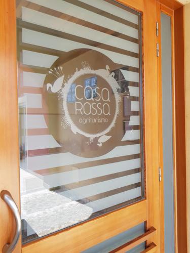 a glass door with a cosa rosa sign on it at Agriturismo Casa Rossa in Postioma