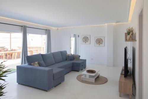 un soggiorno con divano blu e TV di Chalet Marpacos a Santa Cruz de Tenerife
