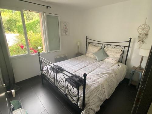 une chambre avec un lit noir et une fenêtre dans l'établissement Villa Sylva, à Sarlat-la-Canéda