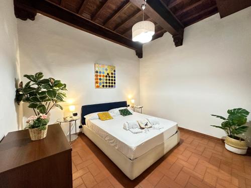 a bedroom with a large white bed and two potted plants at Luxurious View on Santa Croce in Florence