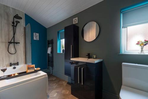 ein Badezimmer mit einem Waschbecken, einer Badewanne und einem Spiegel in der Unterkunft Big House, and a lot to give! in Middlesbrough