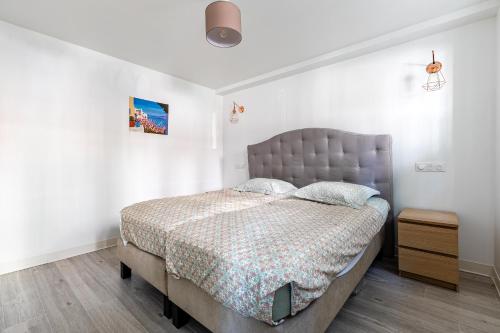 une chambre avec un lit dans une pièce blanche dans l'établissement Strasbourg centre Oberlin, à Strasbourg