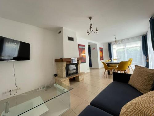 a living room with a couch and a dining room at Maison de vacances familiale in Ouistreham