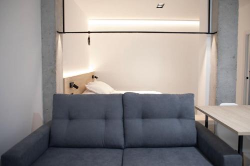 een blauwe bank in een kamer met een bed bij Ponteloft - Curriño in Pontevedra
