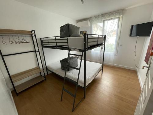 a room with two bunk beds and a television at Maison de vacances familiale in Ouistreham