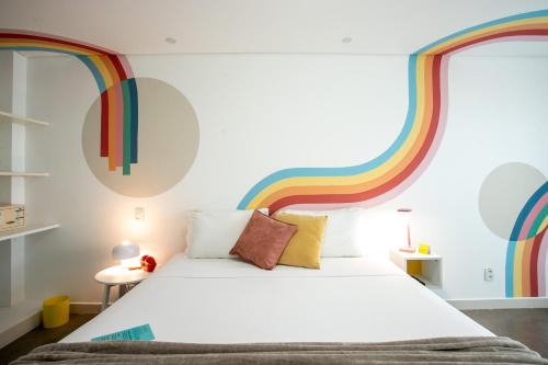 a bedroom with a bed with a rainbow wall at Kembali Hotel Porto de Galinhas - Adults Only in Porto De Galinhas