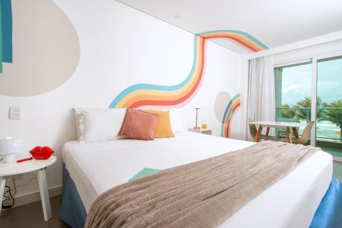 a bedroom with a bed and a rainbow wall at Kembali Hotel Porto de Galinhas - Adults Only in Porto De Galinhas