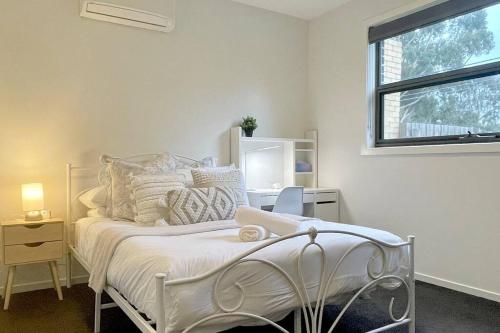 a bedroom with a white bed and a window at Home from Home Cozy Beauty Park Front in Melbourne