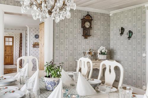 une salle à manger avec une table et une horloge murale dans l'établissement Stubbegården - Unique swedish style, à Vadstena