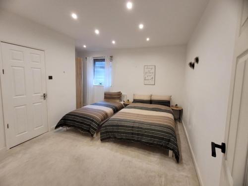 2 Betten in einem Zimmer mit weißen Wänden in der Unterkunft The Woodland Hotel in Blackpool
