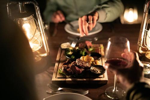 a table with a plate of food and a glass of wine at Simbavati Trails Camp in Timbavati Game Reserve