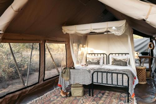 a bedroom in a tent with a bed at Simbavati Trails Camp in Timbavati Game Reserve