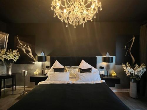 a bedroom with a large bed and a chandelier at Platin City Apartment in Hamburg