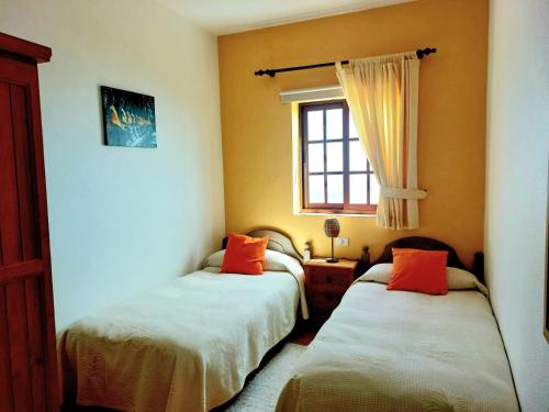 バルロベントにあるLas Paredesのベッドルーム1室(オレンジ色の枕が備わるベッド2台付)