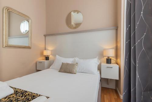 a bedroom with a white bed and a mirror at Milan Retreats in Milan
