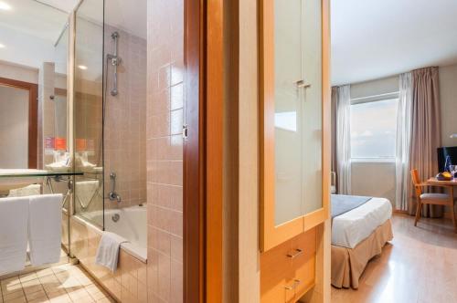 uma casa de banho com um chuveiro, uma cama e uma banheira em Posadas De España Paterna em Paterna
