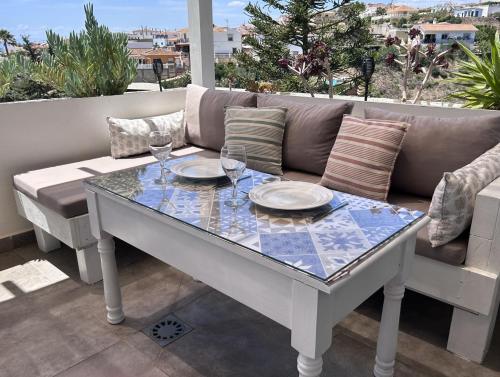 een tafel met wijnglazen en een bank op een patio bij La Casita en Benajarafe in Málaga