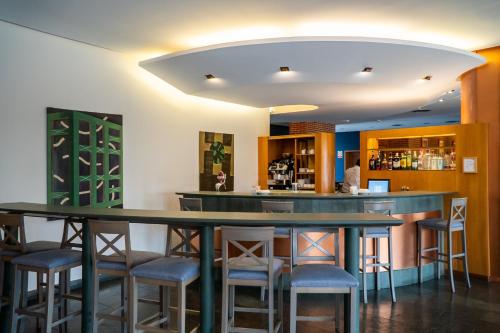 a bar in a restaurant with stools around it at Posadas De España Paterna in Paterna