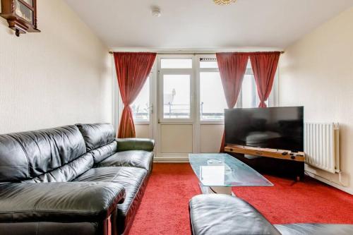 a living room with a couch and a flat screen tv at One Bed (Entire Flat) - 25 mins from London Bridge in London