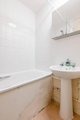 a white bathroom with a sink and a mirror at One Bed (Entire Flat) - 25 mins from London Bridge in London