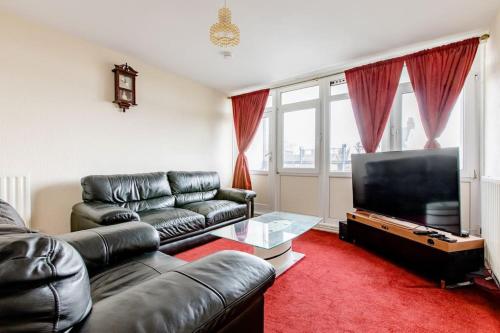a living room with a leather couch and a flat screen tv at One Bed (Entire Flat) - 25 mins from London Bridge in London