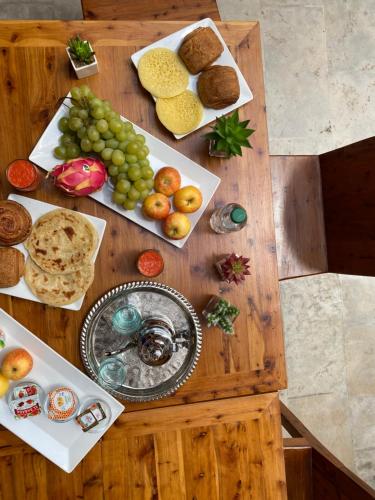 a wooden table with plates of food on it at Riad El Pacha in Rabat