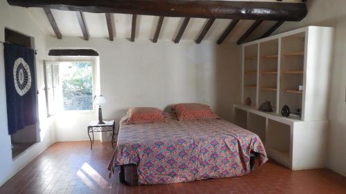 sypialnia z łóżkiem i oknem w obiekcie La bergerie w mieście La Garde-Freinet