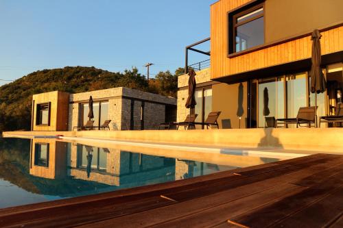 a house with a swimming pool in front of it at Heterotopia Villas in Chortáta