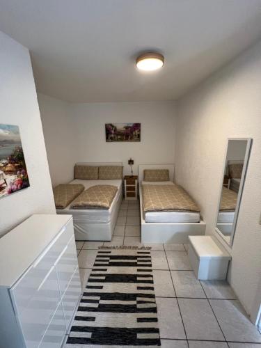 Cette petite chambre comprend 2 lits et un miroir. dans l'établissement Alex Apartments, à Solingen