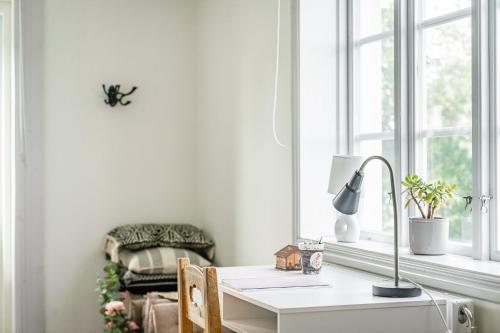 cocina con escritorio, lámpara y silla en STUBBET - Charming - Newly Remade Villa, en Vadstena