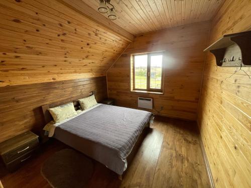 ein Schlafzimmer in einem Blockhaus mit einem Bett in der Unterkunft 4REST 