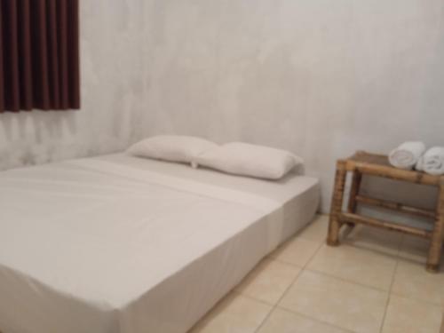 um quarto com uma cama e uma mesa lateral com toalhas em Hendi Homestay em Gili Gede