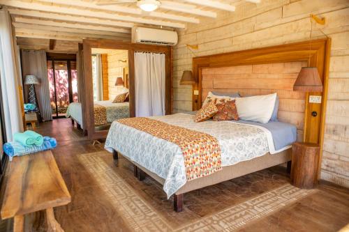 a bedroom with a bed and a wooden wall at Latica Lodge in Playa Negra