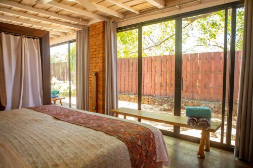 a bedroom with a bed and a large window at Latica Lodge in Playa Negra