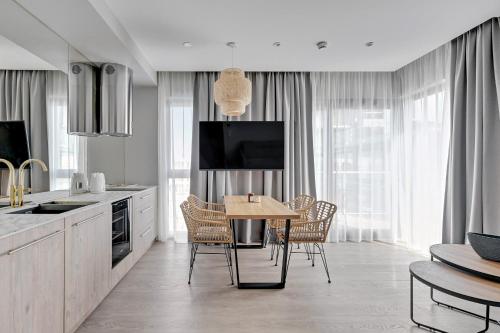 a kitchen with a table and chairs and a television at GRANO HOTEL Solmarina in Wiślinka