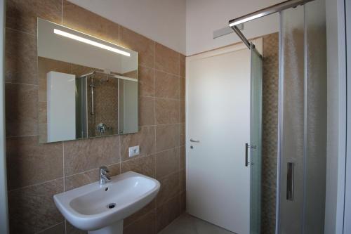 bagno con lavandino e doccia con specchio di Ginny House a Toscolano Maderno