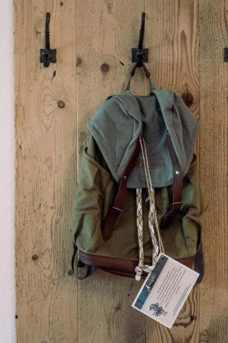 a green backpack sitting on a wooden table with a tag at Alpengasthof Hochsöll in Söll