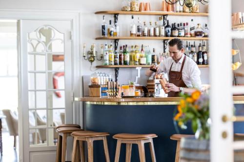 a man standing at a bar using a cell phone at Stella Maris in Svendborg