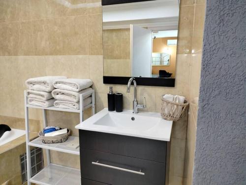 y baño con lavabo, espejo y toallas. en Suite dreams, en Netiv HaShayyara