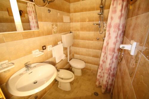a bathroom with a toilet and a sink at Bibione Beach Apartments in Bibione