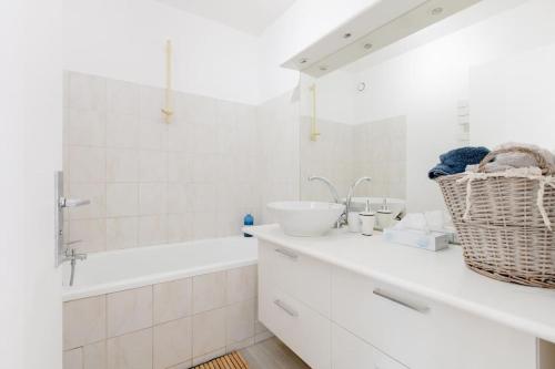 a white bathroom with a sink and a bath tub at 3 P lumineux, wifi&parking free proche du lycée international et de La Défense in Saint-Germain-en-Laye