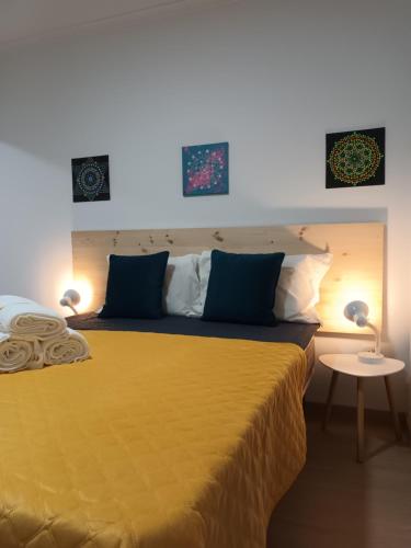 um quarto com uma grande cama amarela e 2 candeeiros em Casa Ocre Alojamento Local em Abrantes