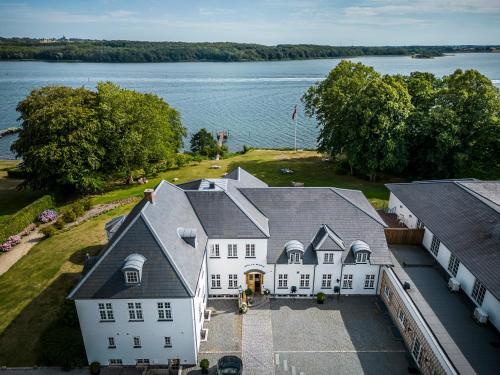 een luchtzicht op een groot wit huis met een meer bij Stella Maris in Svendborg